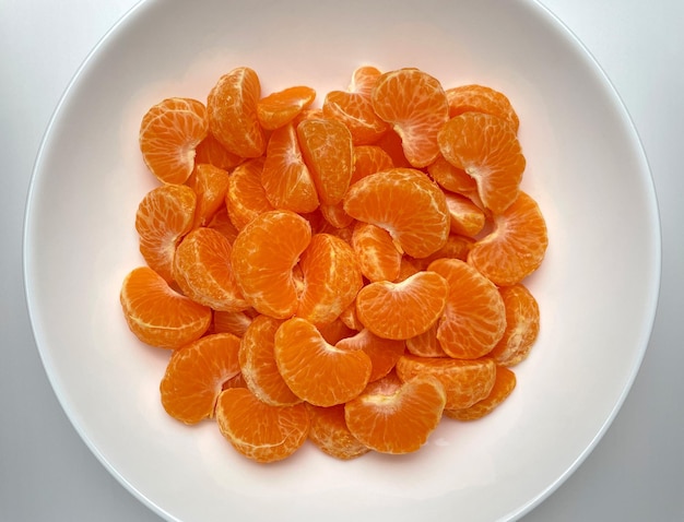 Photo tranches de mandarine dans une vue de dessus de plaque blanche