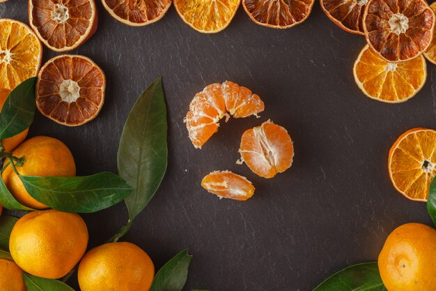 les tranches de mandarine se décomposent sur les bords de la table en ardoise