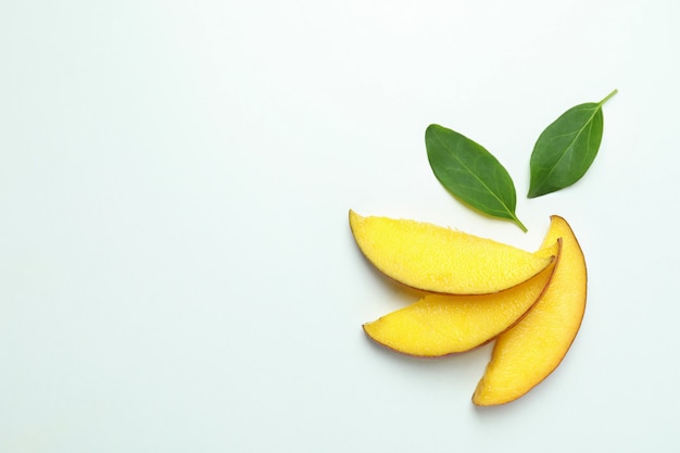 Tranches de mangue mûres sur une surface blanche