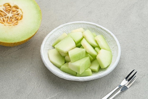 Tranches de melon cantaloup servi dans une petite assiette sur fond gris Mise au point sélectionnée