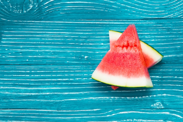 Photo tranches de melon d'eau rouge sur fond bleu