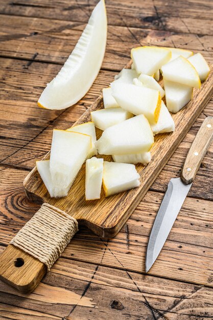 Tranches de melon jaune sur la planche à découper