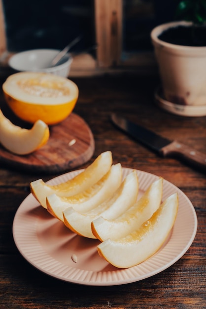 Des tranches de melon mûr sur une assiette sur une surface rustique