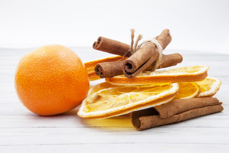 Photo tranches d'orange à la cannelle et mandarine sur fond en bois