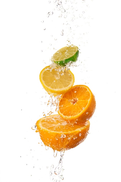 Tranches d'orange, de citron et de kiwi les unes sur les autres et de l'eau courante sur le dessus.