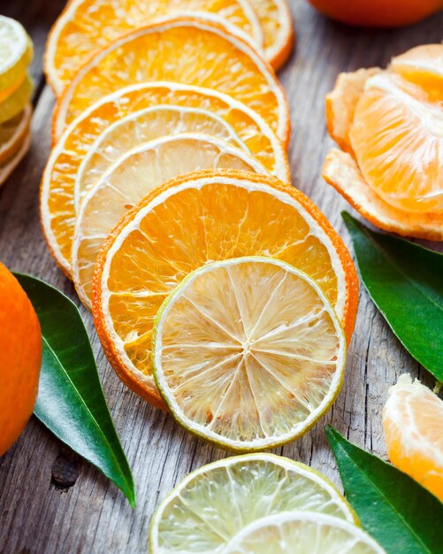 Tranches d'orange et de citron séchées mandarines mûres sur une vieille table en bois