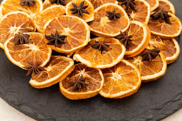 Tranches d'orange déshydratée et anis étoilé sur pierre noire. Mise au point sélective.