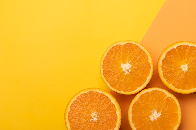 Tranches d'orange fraîche sur un fond coloré