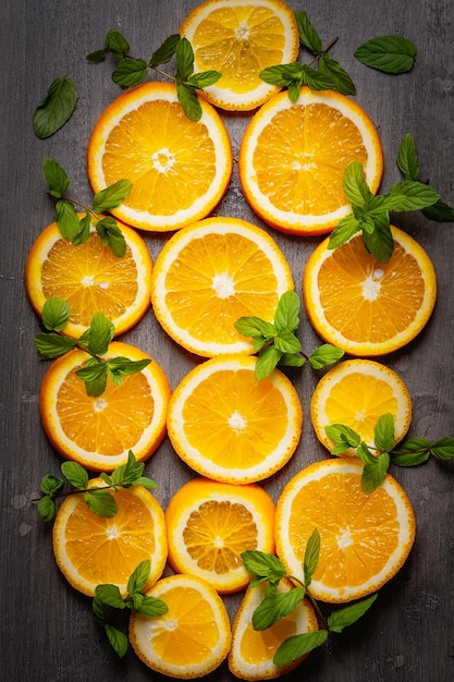 Des tranches d'orange et de menthe sur un fond gris