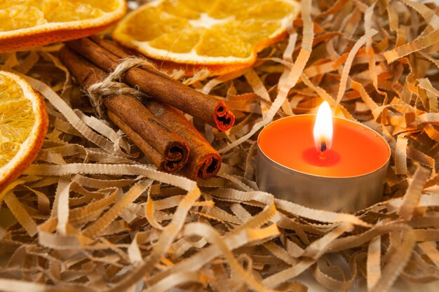 Tranches d'orange séchées, bâtons de cannelle et une bougie