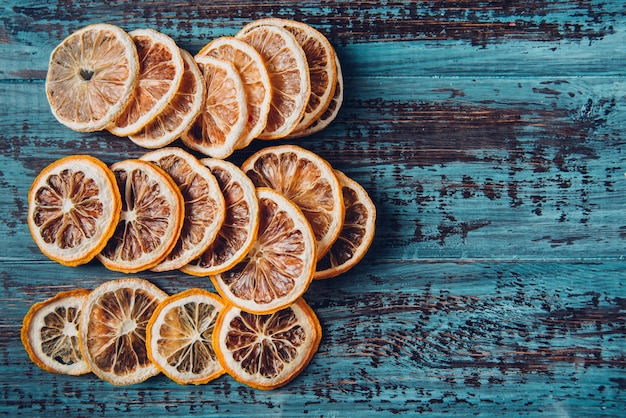 Tranches d'orange séchées sur une table en bois, mise au point sélective et image tonique. Table en bois bleu rustique