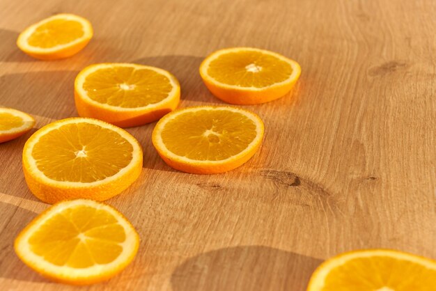 Tranches d'oranges biologiques fraîches obn une table de cuisine en bois.