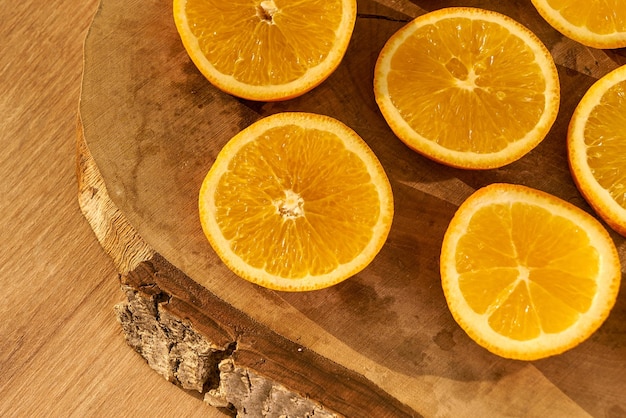 Tranches d'oranges biologiques fraîches sur une planche à découper en bois