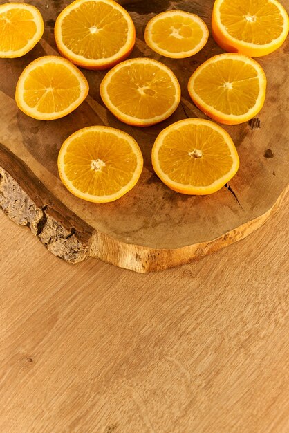 Tranches d'oranges biologiques fraîches sur une table de cuisine en bois.