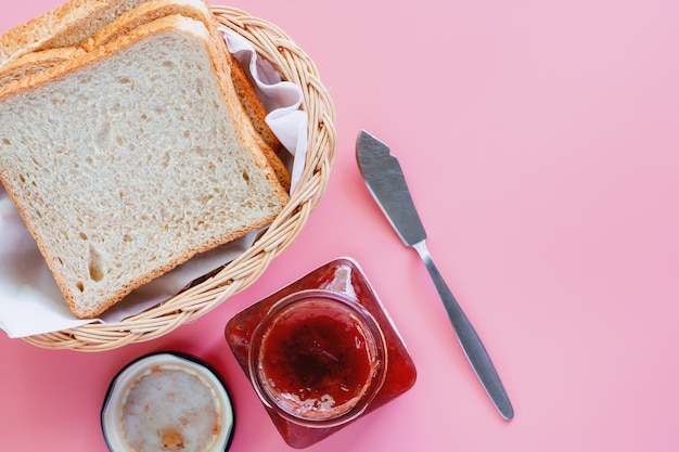 Tranches de pain de blé entier à la fraise sur fond rose