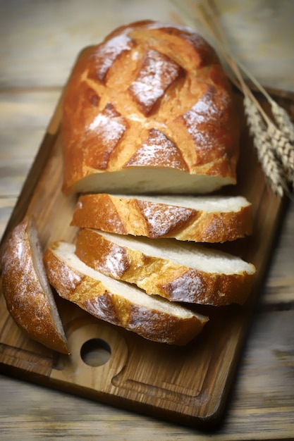 Tranches de pain de blé frais sur une surface en bois