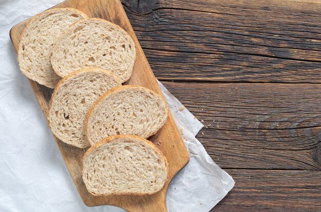 Tranches de pain de blé sur une planche à découper