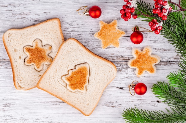 Tranches de pain grillé avec des toasts découpés en forme de sapin et de flocon de neige