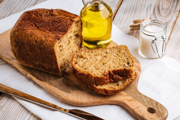 Tranches de pain noir sur une planche de bois avec du sel et de l'huile d'olive