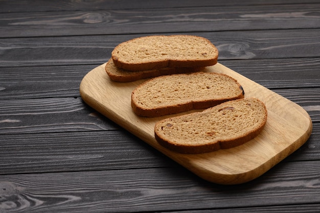 Tranches de pain de seigle sur une planche sur une table en bois