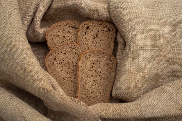 Des tranches de pain de seigle se trouvent sur une nappe en lin