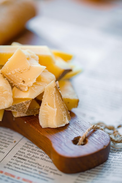 Tranches de parmesan sur le plateau. Morceaux de fromage sur le plateau. Fromage à pâte dure pour le vin