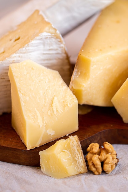 Tranches de parmesan sur le plateau. Morceaux de fromage sur le plateau. Fromage à pâte dure pour le vin