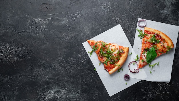 Tranches de pizza italienne sur fond sombre aux épinards