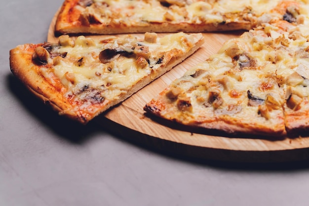 Tranches de pizza sur plateau en bois rustique et fond sombre