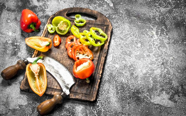 Tranches de poivrons doux sur une vieille planche à découper.