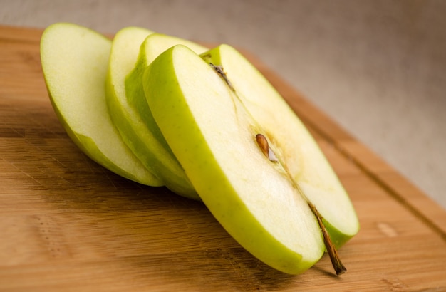 Tranches de pomme verte sur une planche à découper