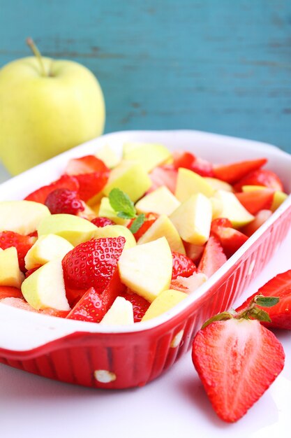 Tranches de pommes et de fraises dans un plat allant au four