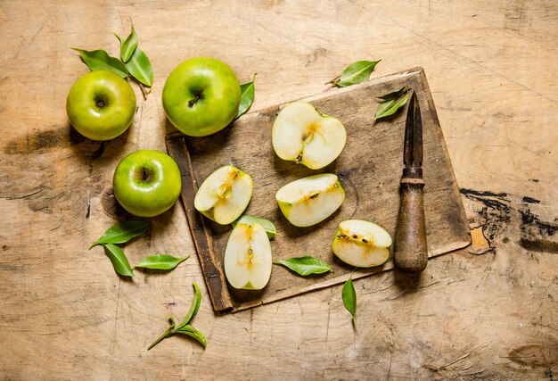 Tranches de pommes vertes sur une planche de bois. Sur une table en bois. Vue de dessus