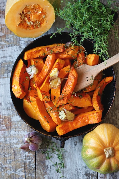 Photo tranches de potiron au thym et à l'ail dans une casserole.