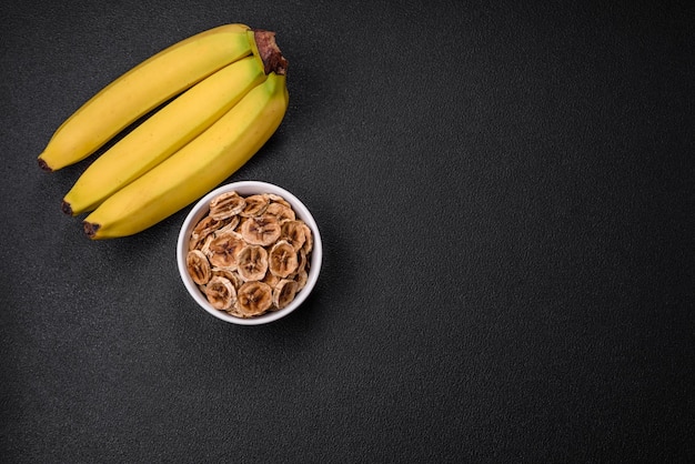 Tranches rondes de banane sucrée sur fond de béton foncé Ingrédients pour faire des bonbons végétaliens