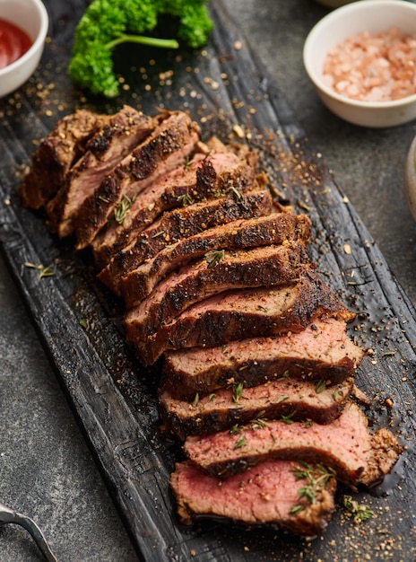 Tranches De Steak De Boeuf Grillé Sur Une Planche à Découper Au-dessus De La Table Grise Recette De Filet Mignon De Steak De Boeuf