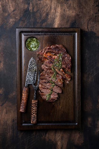 Tranches de steak sur planche de bois foncé