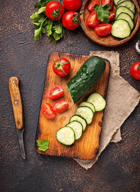 Tranches de tomate et concombre sur une planche à découper