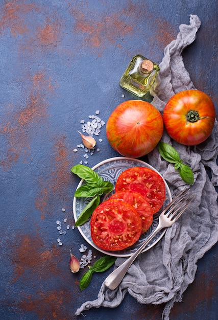 Tranches de tomate sur fond bleu rouillé