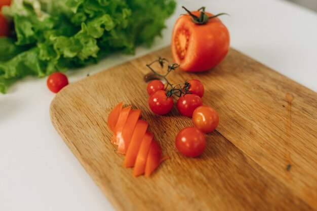 Tranches de tomate sur une planche de cuisine Beaucoup de légumes sur la table