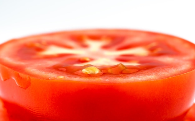 Photo tranches de tomate rouge sur fond blanc morceau rond de tomate fraîche fond macro