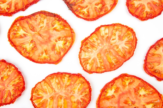 Tranches de tomate séchée sur fond blanc. nourriture végétale vitaminée