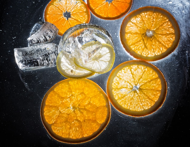 Tranches transparentes d&#39;oranges et de citrons sur le verre