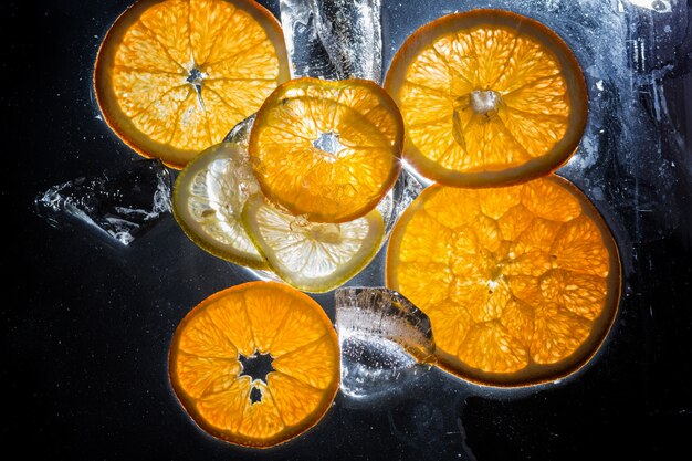 Tranches transparentes d&#39;oranges et de citrons sur le verre