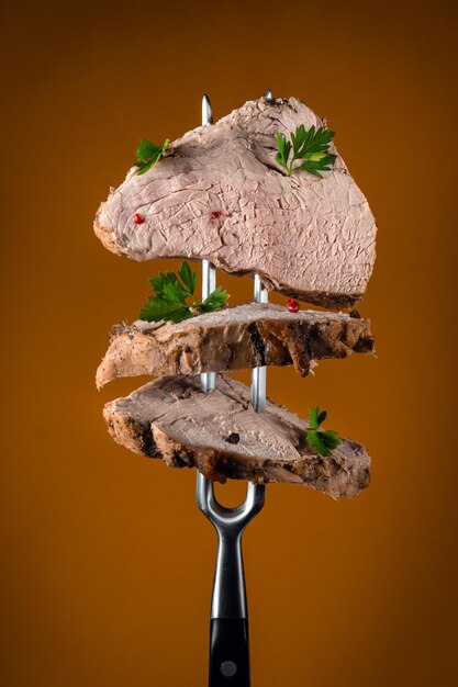 Tranches de viande cuite au four avec aneth et épices sur une fourchette Concept de menu pour hôtel ou restaurant Aliments biologiques