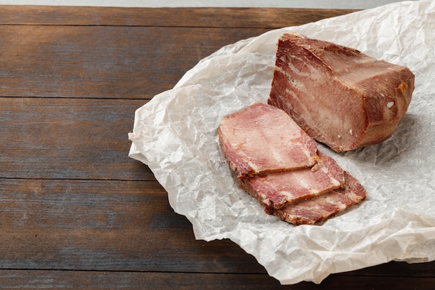 Tranches de viande de porc cuit au four sur fond de bois