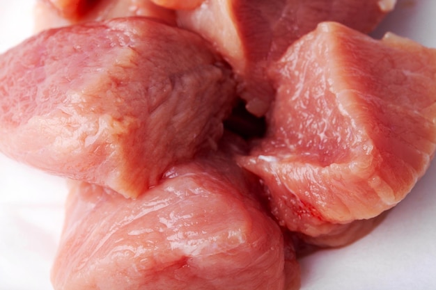 Tranches de viande rouge crue prêtes pour la cuisson sur fond blanc isolé gros plan