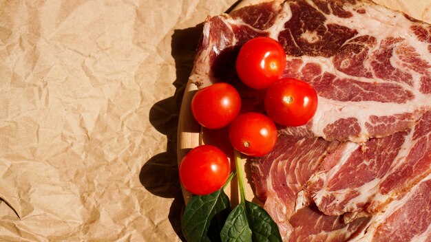 Tranches de viande et tomates cerises. Ingrédients pour sandwich et bruschetta. Cuisiner des collations. Feuilles d'épinards.