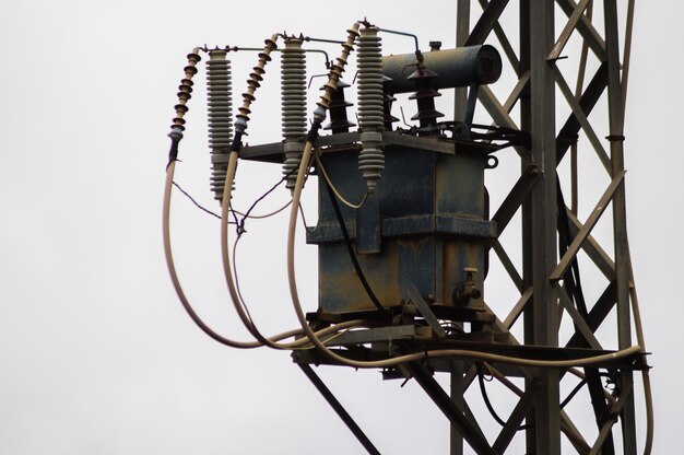 Photo transformateur sur un pylône électrique contre un ciel dégagé