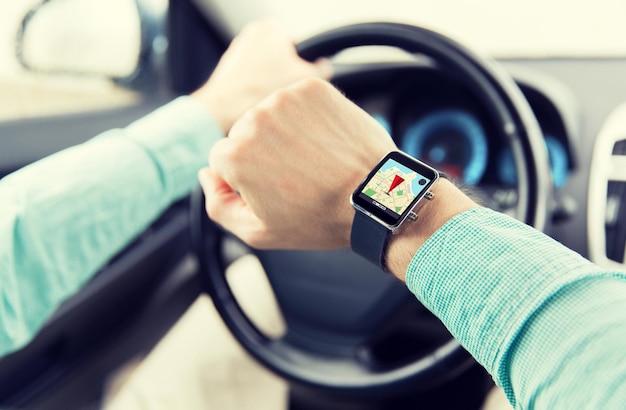 transport, voyage d'affaires, technologie, navigation et concept de personnes - gros plan d'un homme avec smartwatch conduisant une voiture et utilisant un navigateur gps